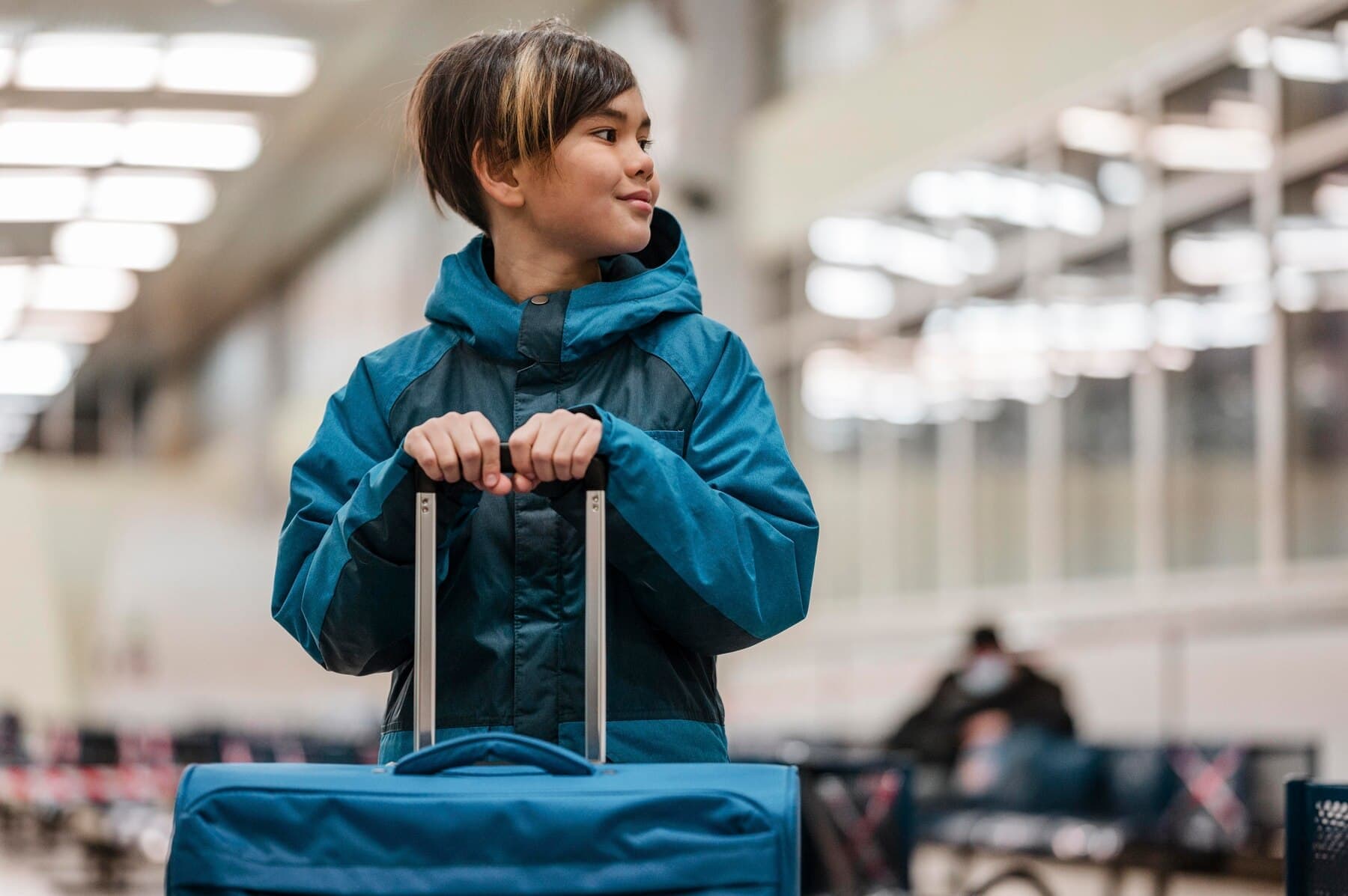 Child holding luggage at airport representing child green card